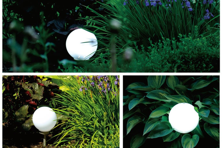 Zahradní lampa kulatá venku mezi rostlinami