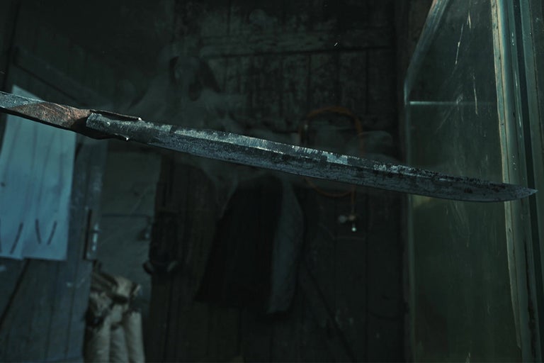 Opotřebovaný meč na pozadí nepořádku.