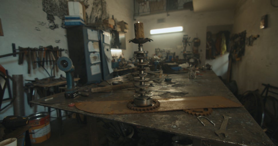 Dílna s nářadím, pracovní stůl a svícen vyrobený z kovových dílů.