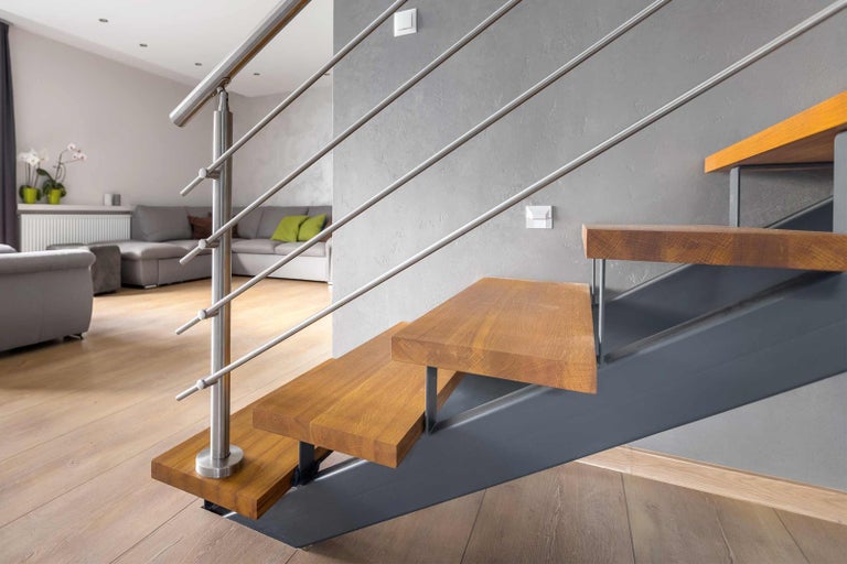Schodiště s dřevěnými stupni a kovovým zábradlím v obývacím pokoji