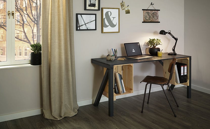 Pracovna se stolem z dřevěných beden, židlí a pokojovými rostlinami