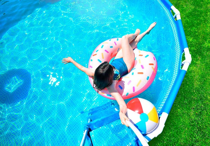 Žena relaxuje v bazénu na plovacím kruhu ve tvaru koblihy