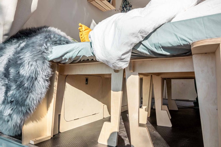 Dřevěný rám postele s úložným prostorem a textilem v interiéru