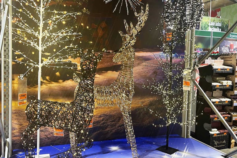 Dekorativní scéna s osvětlenými figurkami sobů a LED stromy pro vánoční období