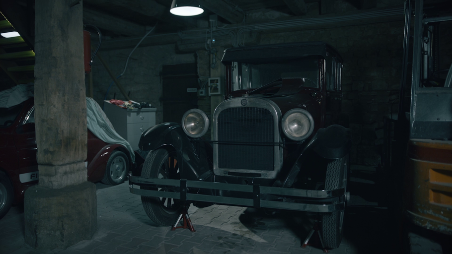 Scéna garáže s veteránem na zvedácích.