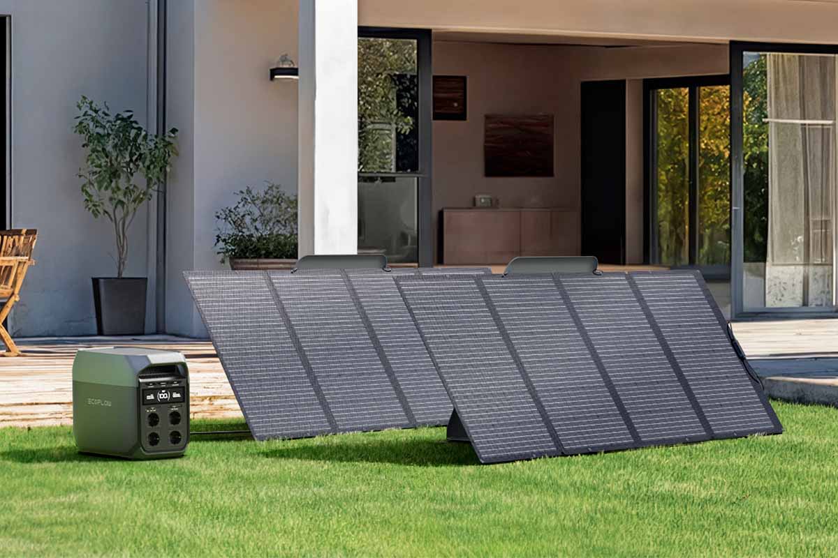 Přenosná napájecí stanice EcoFlow se dvěma skládacími solárními panely na trávníku před moderním domem.