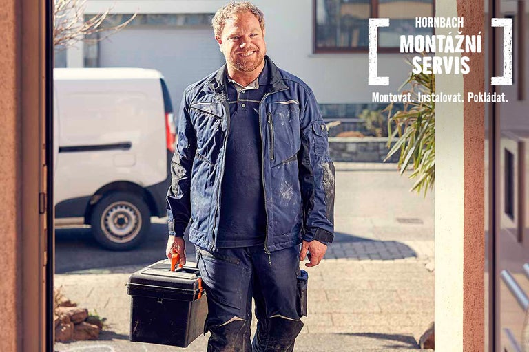 Řemeslník s kufrem na nářadí před dodávkou montážního servisu Hornbach