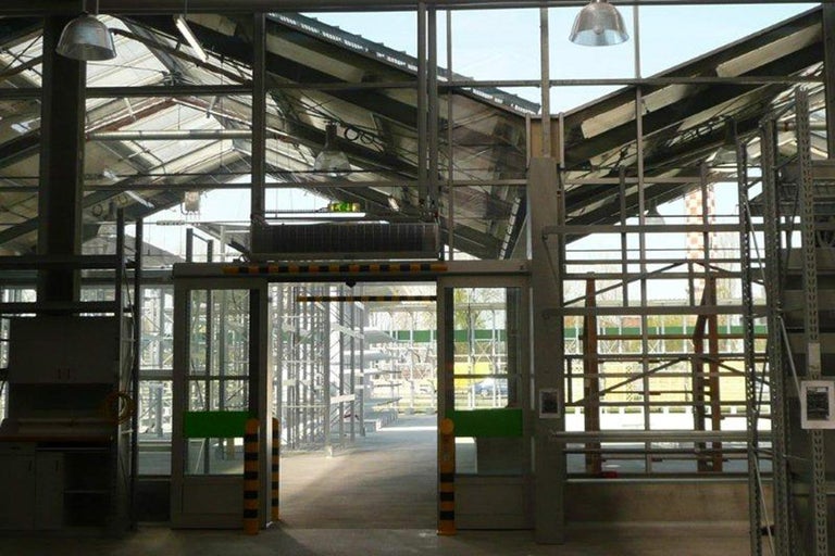 Interiér skleníku s regály a skleněnými dveřmi