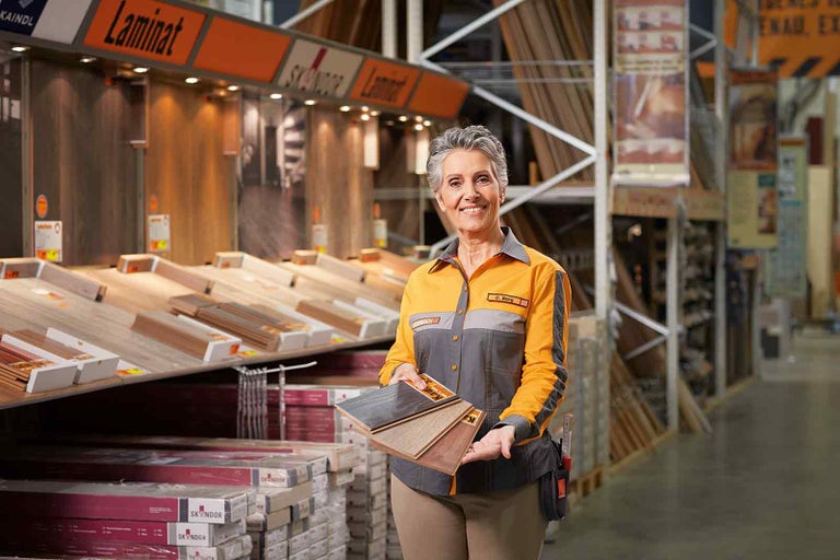 Zaměstnankyně společnosti Hornbach prezentuje laminátové podlahy v různých provedeních.