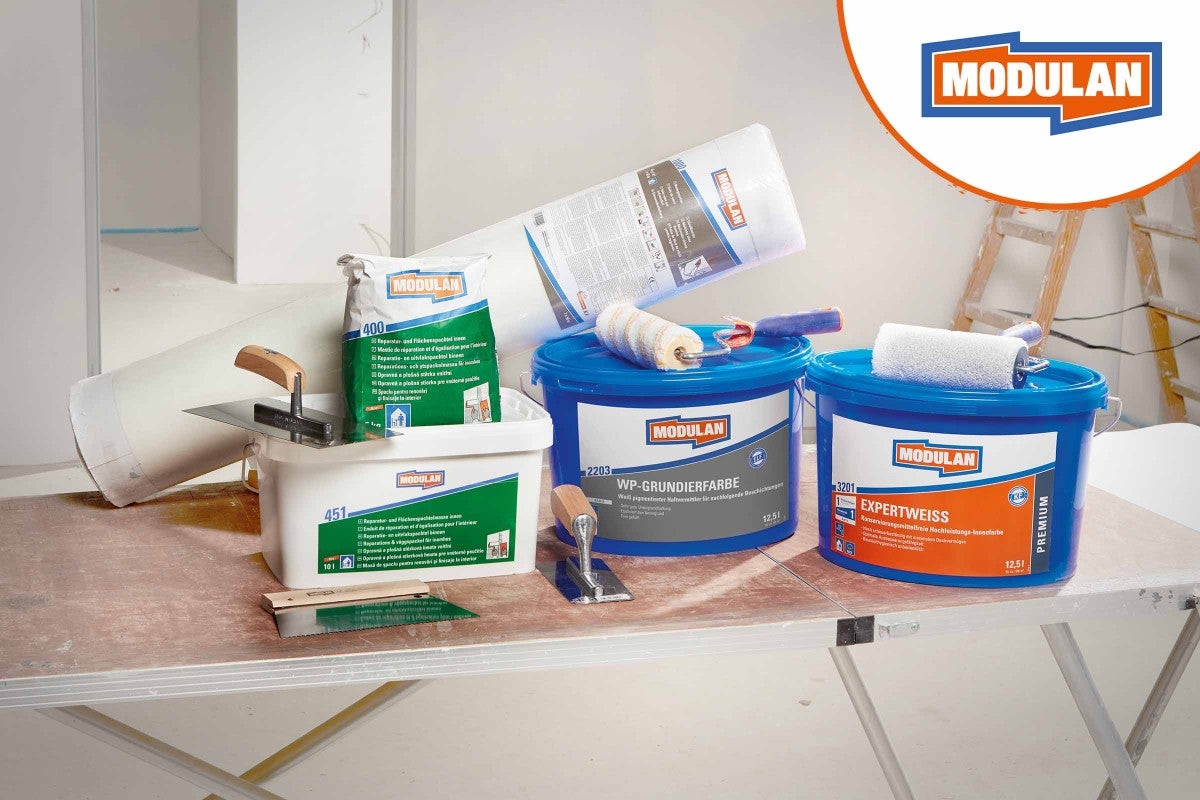Renovační produkty Modulan, včetně tmelu, základního nátěru a kbelíků s barvou, a také nářadí, jako jsou malířské štětce a špachtle.
