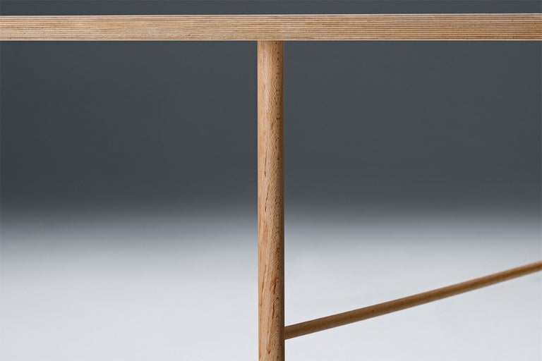 Detailní pohled na dřevěný stůl s kulatýma nohama a dřevěnou deskou