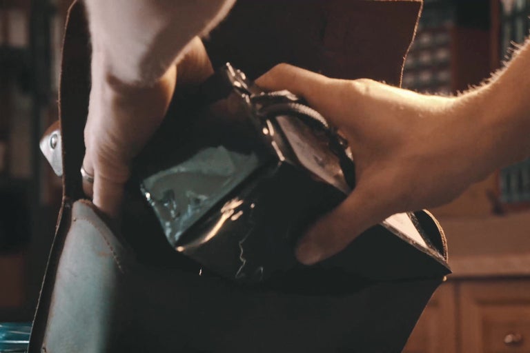 Ruce vkládají zabalený produkt do tašky