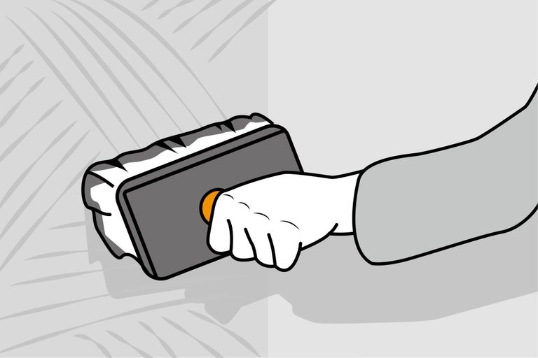 Ruka s benátským hladítkem pro nanášení omítky