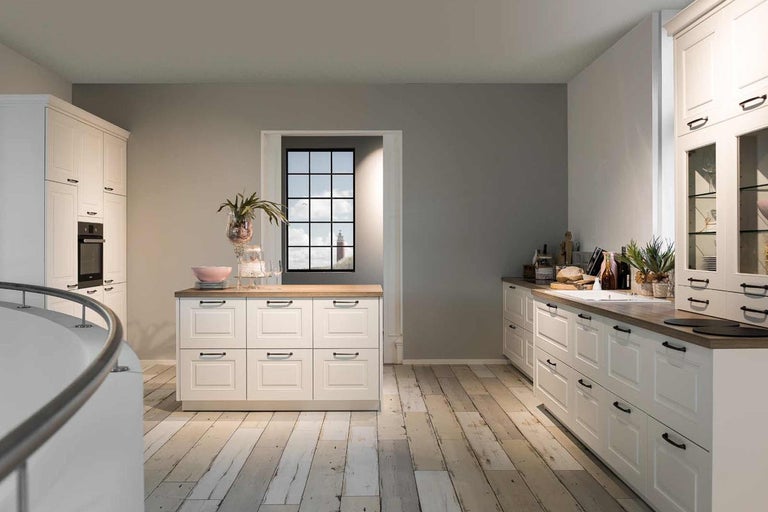 Světlá kuchyně s bílými skříňkami a dřevěnou pracovní deskou