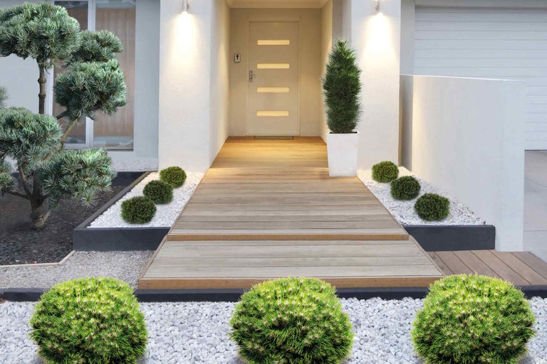 Vstupní prostor s dřevěnou podlahou, rostlinami a bílým štěrkem