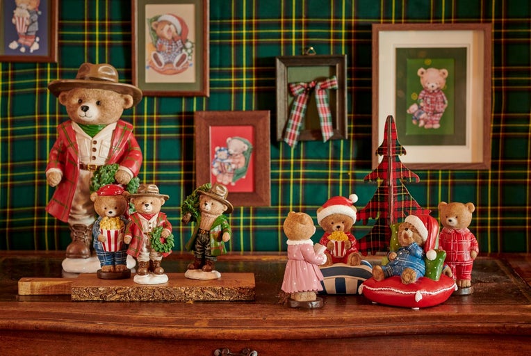 Dekorativní figurky medvědů na dřevěném povrchu s kostkovaným pozadím