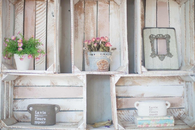 Police s dekorativními prvky, jako jsou květináče, rámy obrazů a knihy