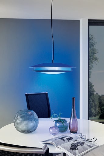 Moderní jídelní prostor s kulatou deskou stolu, židlemi a stylovým závěsným svítidlem