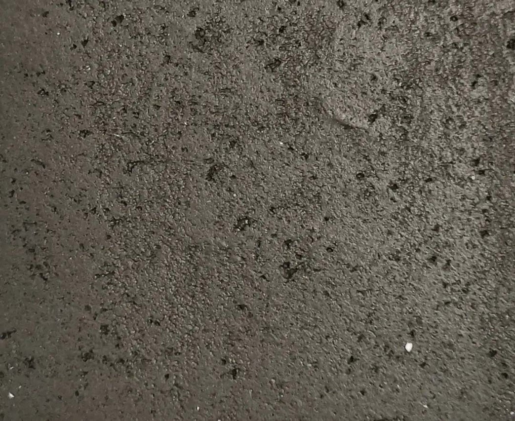 Detailní záběr na nerovný, hrubý povrch se zrnitou strukturou