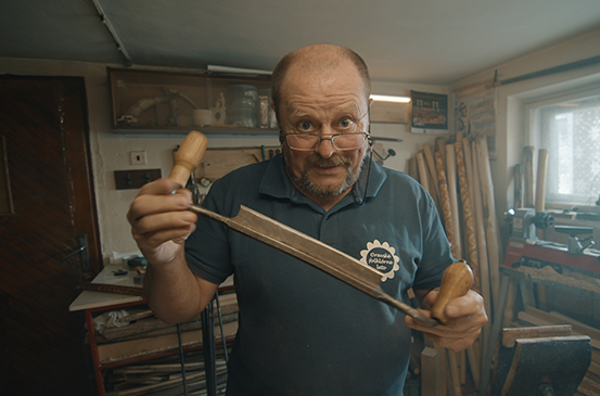 Muž drží v dílně duté dláto