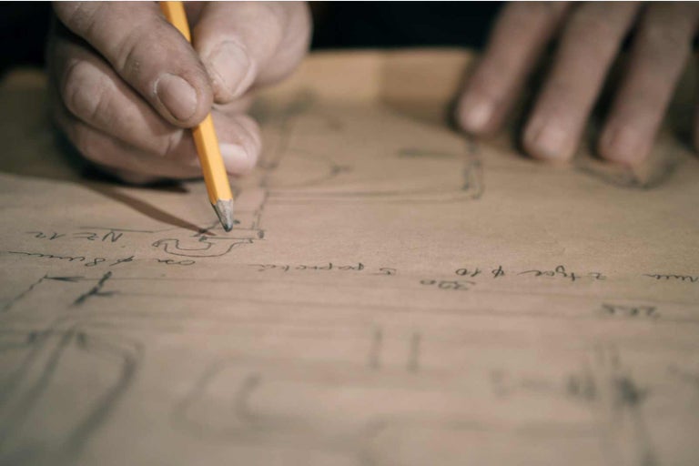 Ruka kreslí náčrt tužkou na papír