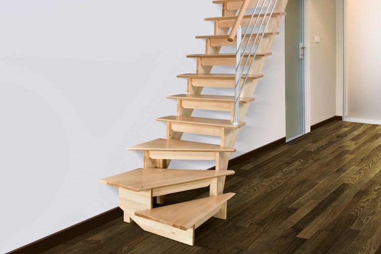 Pohled do místnosti s dřevěným schodištěm s kovovým zábradlím.