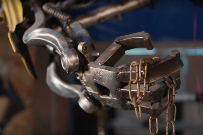 Detail skulptury vyrobené z kovového odpadu s řetězy