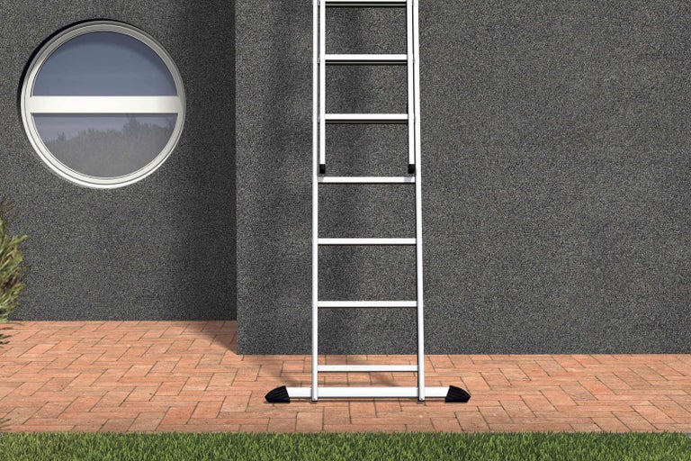 Kovový žebřík u stěny domu s oknem