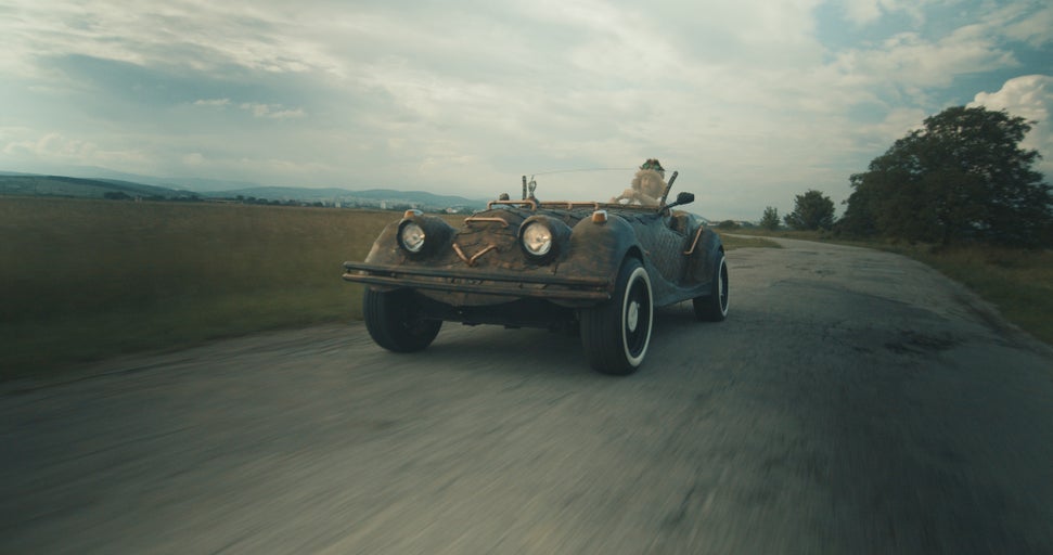 Steampunkové auto jede po silnici.