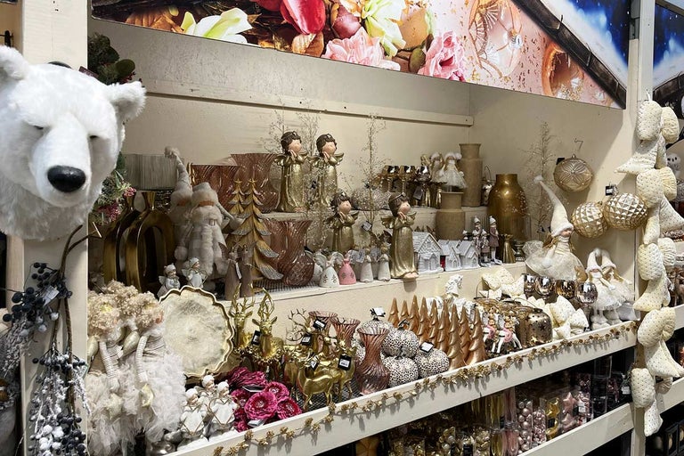 Police s vánočními dekoracemi, jako jsou vázy, figurky a ozdoby