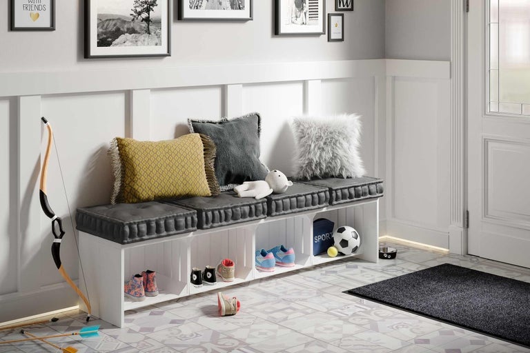 Předsíň s lavicí, polštáři, botami a dekoracemi.