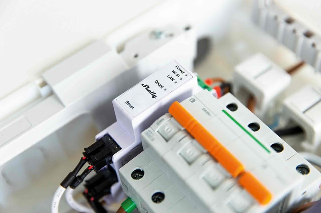 Logo Shelly, elektroměr a jistič v rozvodné skříni