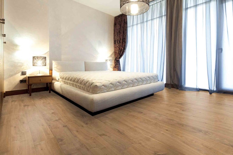 Ložnice s manželskou postelí, nočním stolkem, lampou a závěsy