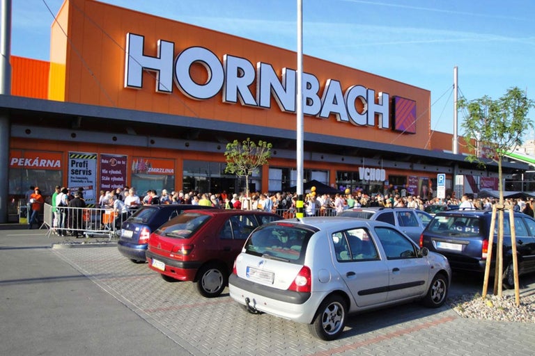 Fasáda hobbymarketu Hornbach s čekajícími davy lidí před vchodem.