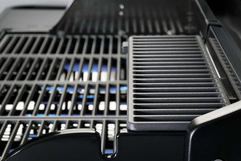 Detail plynového grilu s grilovacími rošty.