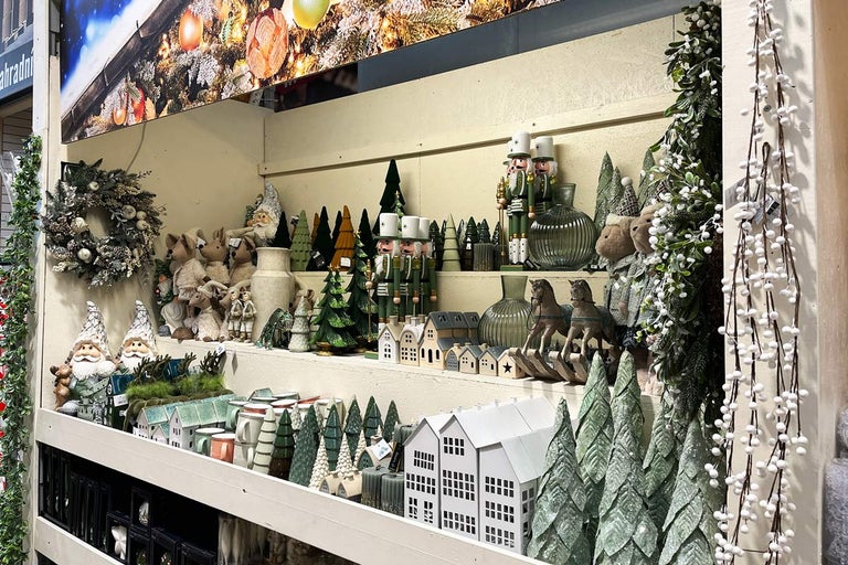 Dekorativní vánoční scéna s figurkami, stromy a domy v regálu