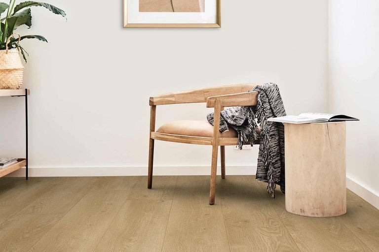 Světlá místnost s dřevěnou podlahou, dřevěnou židlí, dřevěným stolem a dekorací