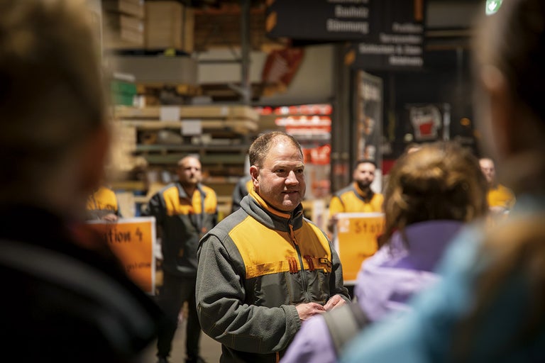 Skupina zaměstnanců společnosti Hornbach stojí v obchodě.