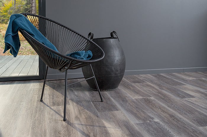 Scéna s podlahovou krytinou ve vzhledu dřeva, křeslem a dekorativním prvkem