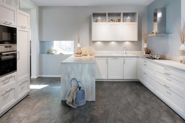 Světlá kuchyně s kuchyňským ostrůvkem, vestavěnými skříněmi a odsavačem par