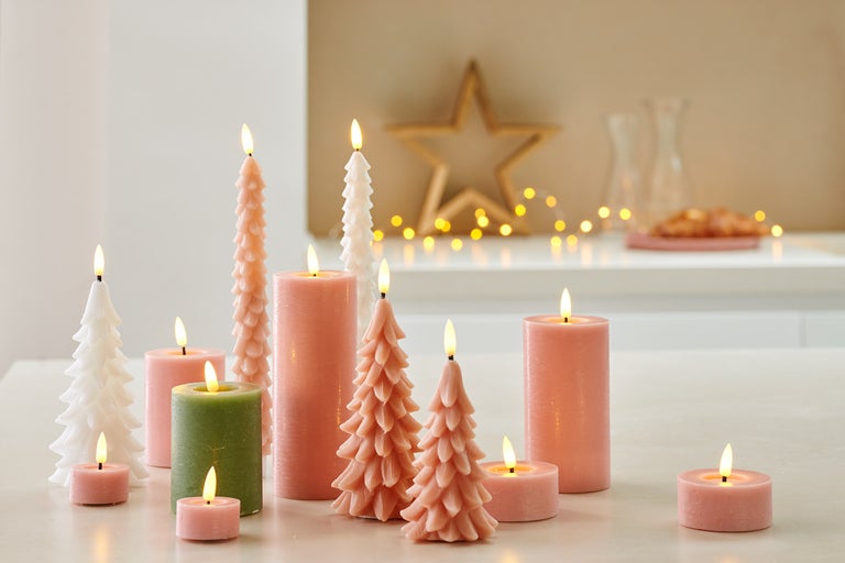 Dekorativní uspořádání svíček různých tvarů a velikostí.