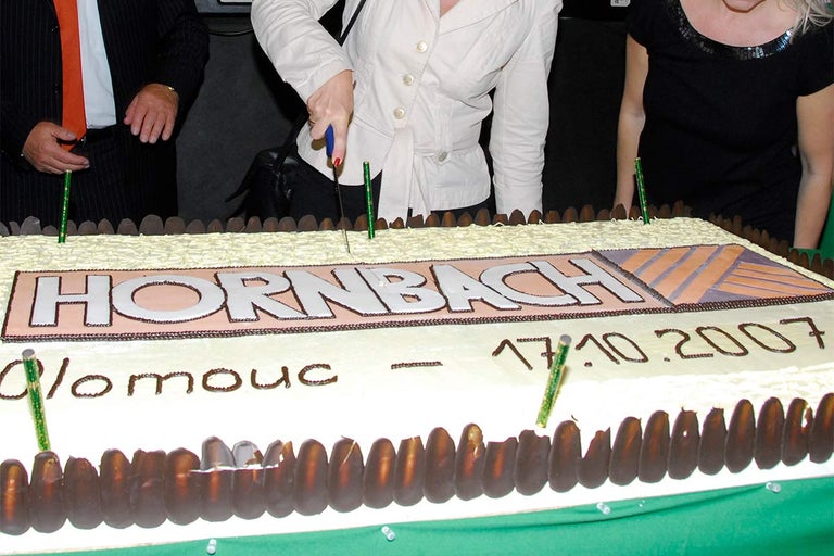 Osoba krájí dort s logem Hornbach a datem 17.10.2007