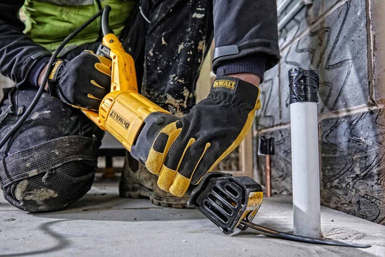 Pracovník řeže trubku pilou ocaskou DeWalt.