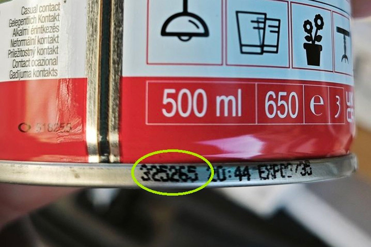 Detailní záběr na plechovku o objemu 500 mililitrů se zaměřením na číslo šarže a datum spotřeby na spodním kovovém okraji.
