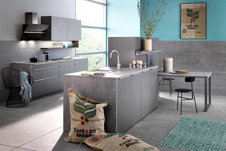 Světlá kuchyně s kuchyňským ostrůvkem, jídelním stolem a dekorativními pytli na kávu