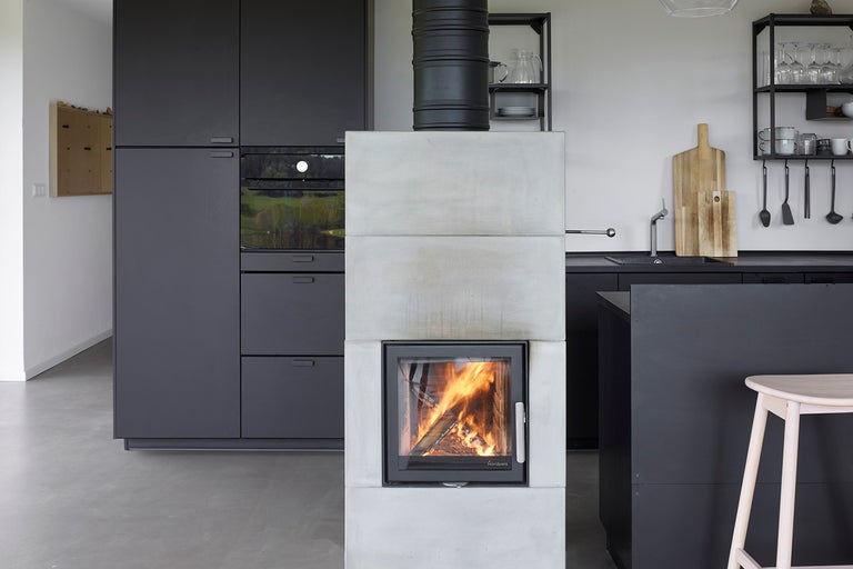 Moderní design kuchyně s krbovými kamny, kuchyňskými skříňkami a policemi.