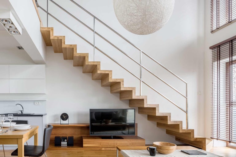 Moderní obývací pokoj s dřevěným schodištěm a nerezovým zábradlím