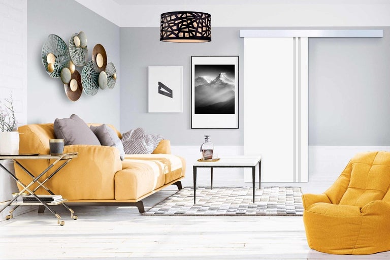 Obývací pokoj s pohovkou, křeslem, konferenčním stolkem, kobercem, nástěnnou dekorací, závěsným svítidlem a posuvnými dveřmi