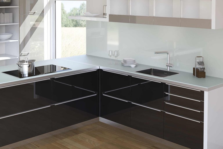 Moderní kuchyně s černými skříňkami, dřezem a varnou deskou.