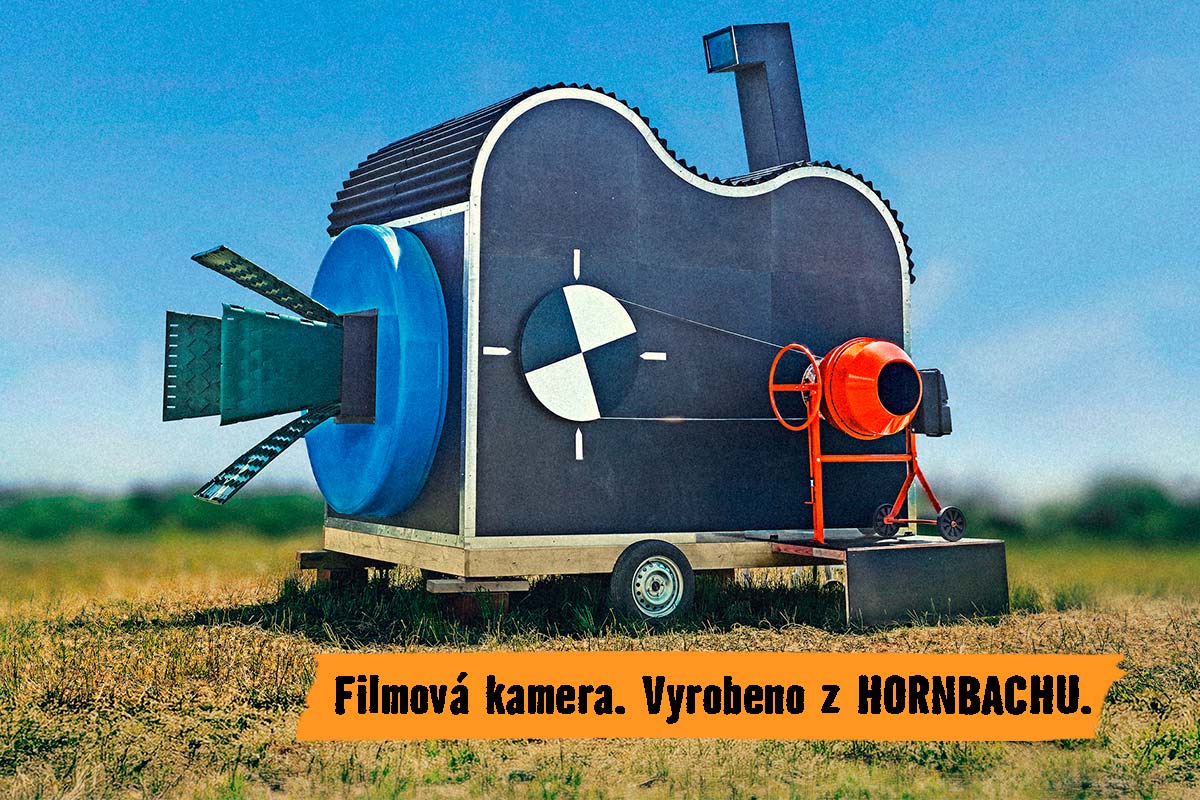 Skulptura ve tvaru filmové kamery vyrobená z různých stavebních materiálů na přívěsu, prezentovaná společností Hornbach.